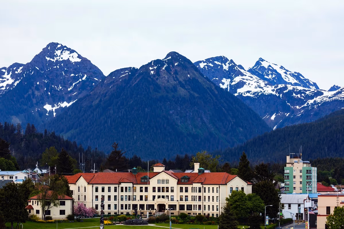 Pioneers' Home Sitka exterior building with snow-capped mountains in background.