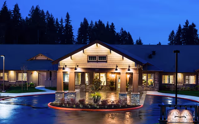 Nighttime exterior view of The Hampton at Salmon Creek entrance with illuminated covered entry.
