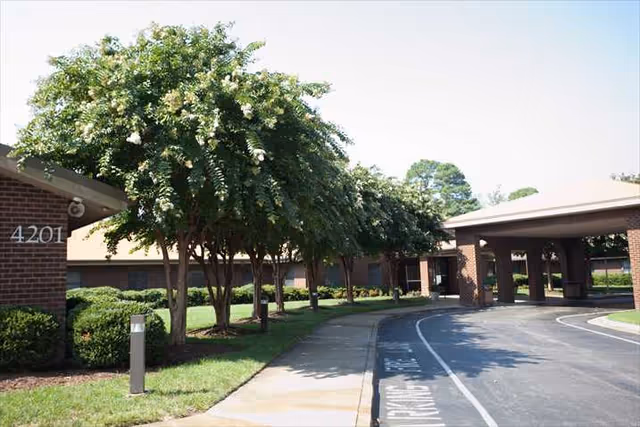 Exterior view of Portside Health & Rehab Center with brick buildings and trees.