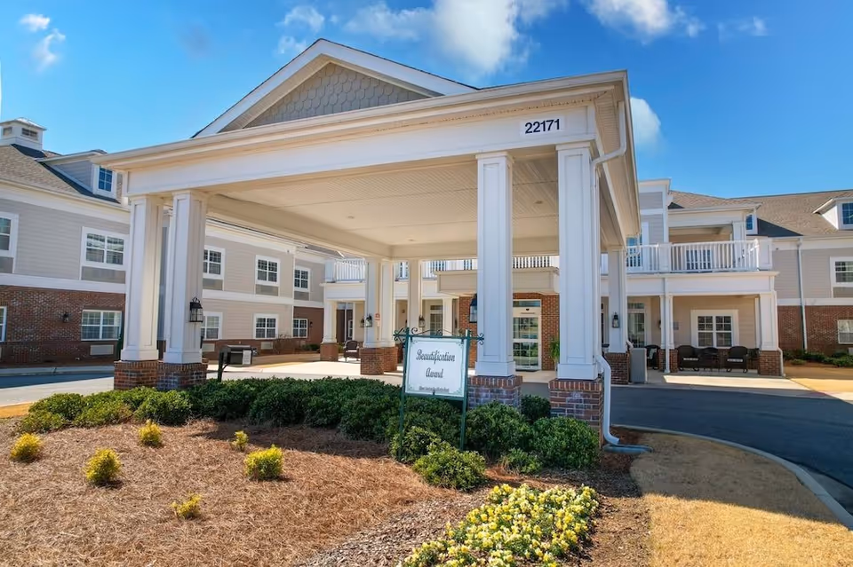 Front entrance porte-cochère of The Goldton at Athens with white columns, landscaping, and address number 22171.