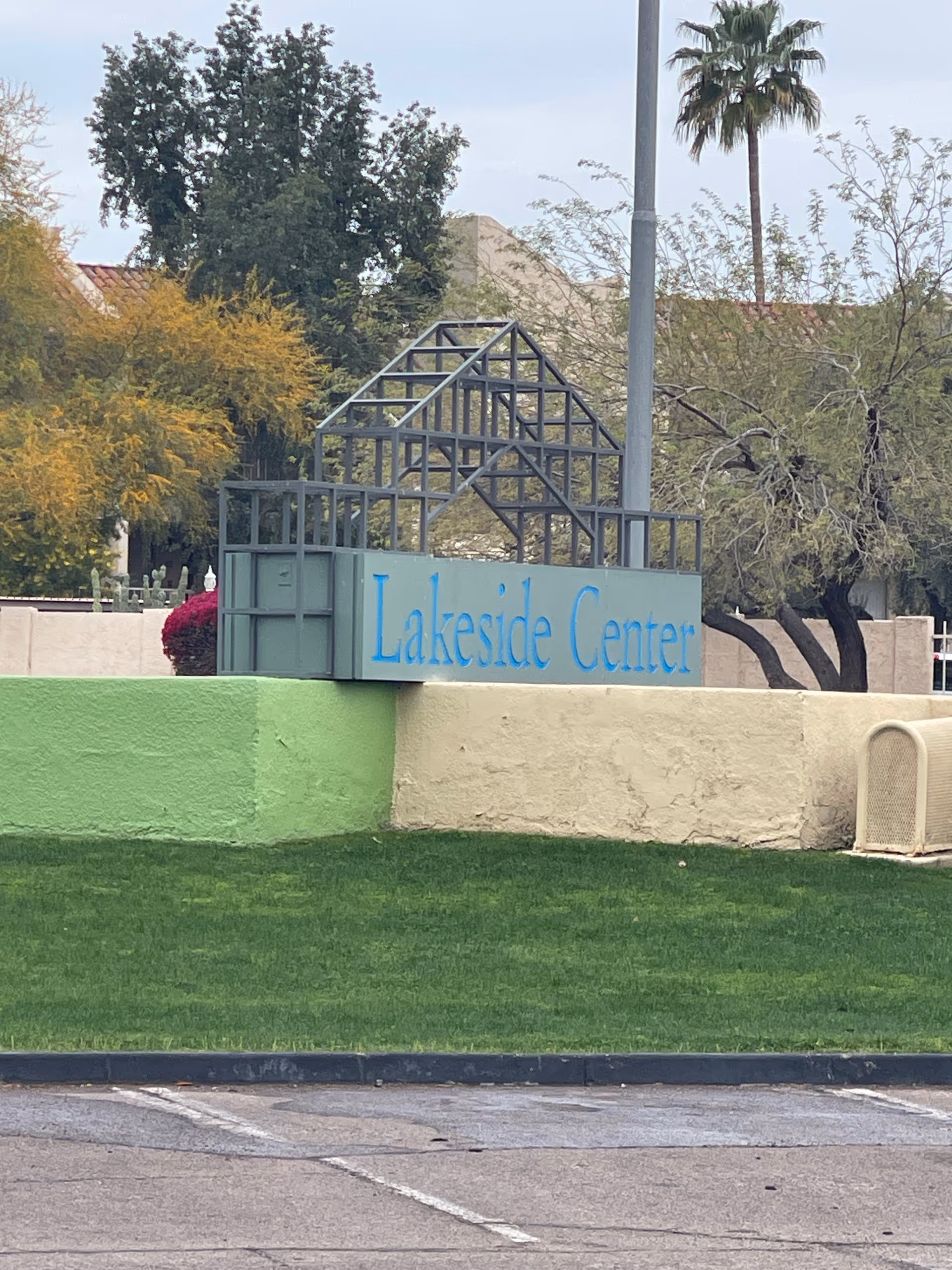 Outdoor view of Lakeside Center sign on grassy area with trees