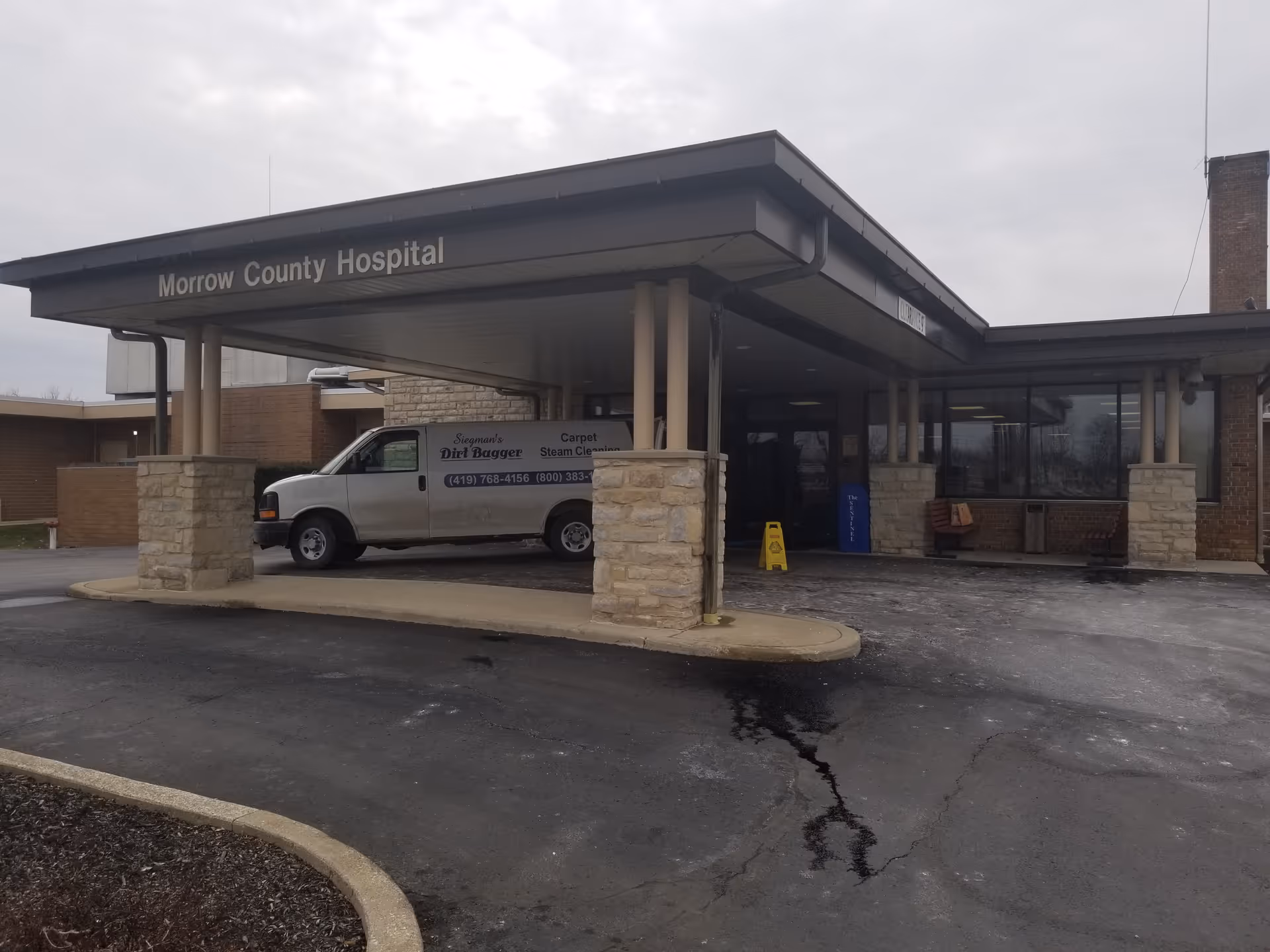Morrow County Hospital entrance with a covered drop-off area and a parked van.