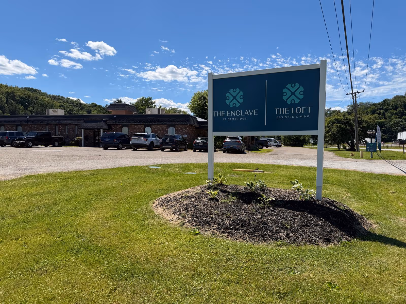 A sign for The Enclave at Cambridge and The Loft Assisted Living in the front yard.