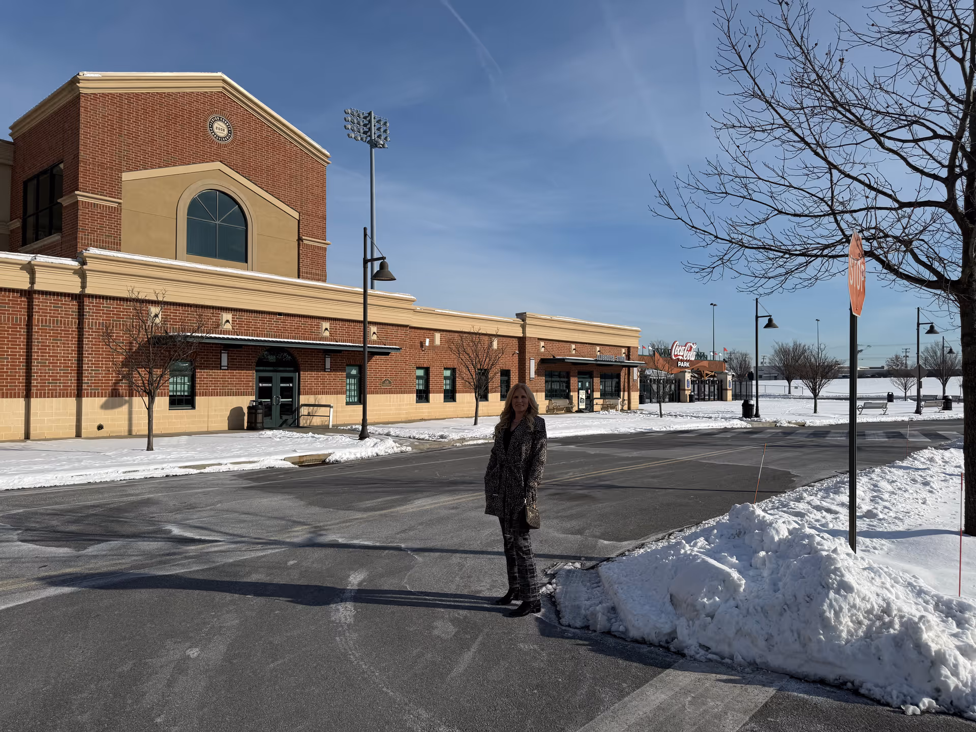 Winter exterior of a brick building with a person standing on a snowy parking lot