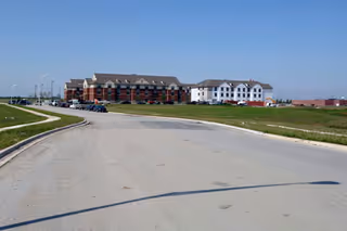 Front exterior of Victory Centre of Sierra Ridge, with parked cars along a circular driveway.