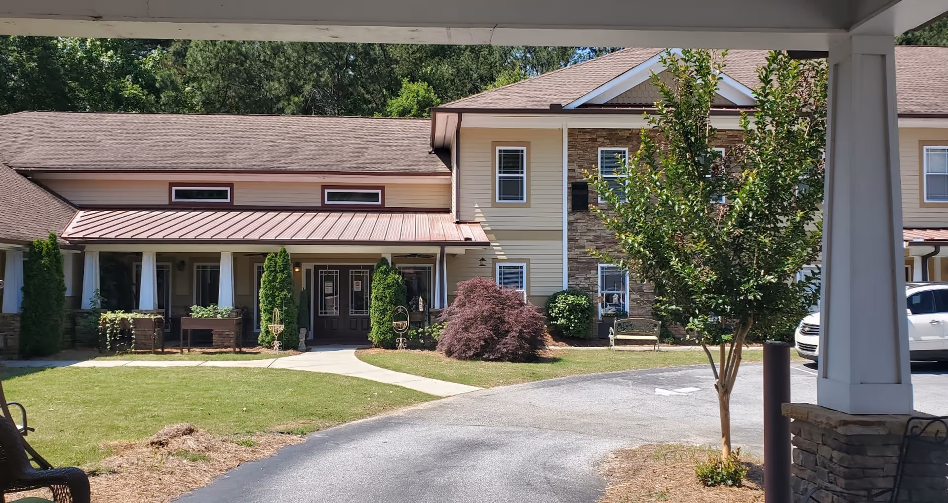 Exterior view of Daybreak Village Assisted Living entrance with lawn and landscaping.