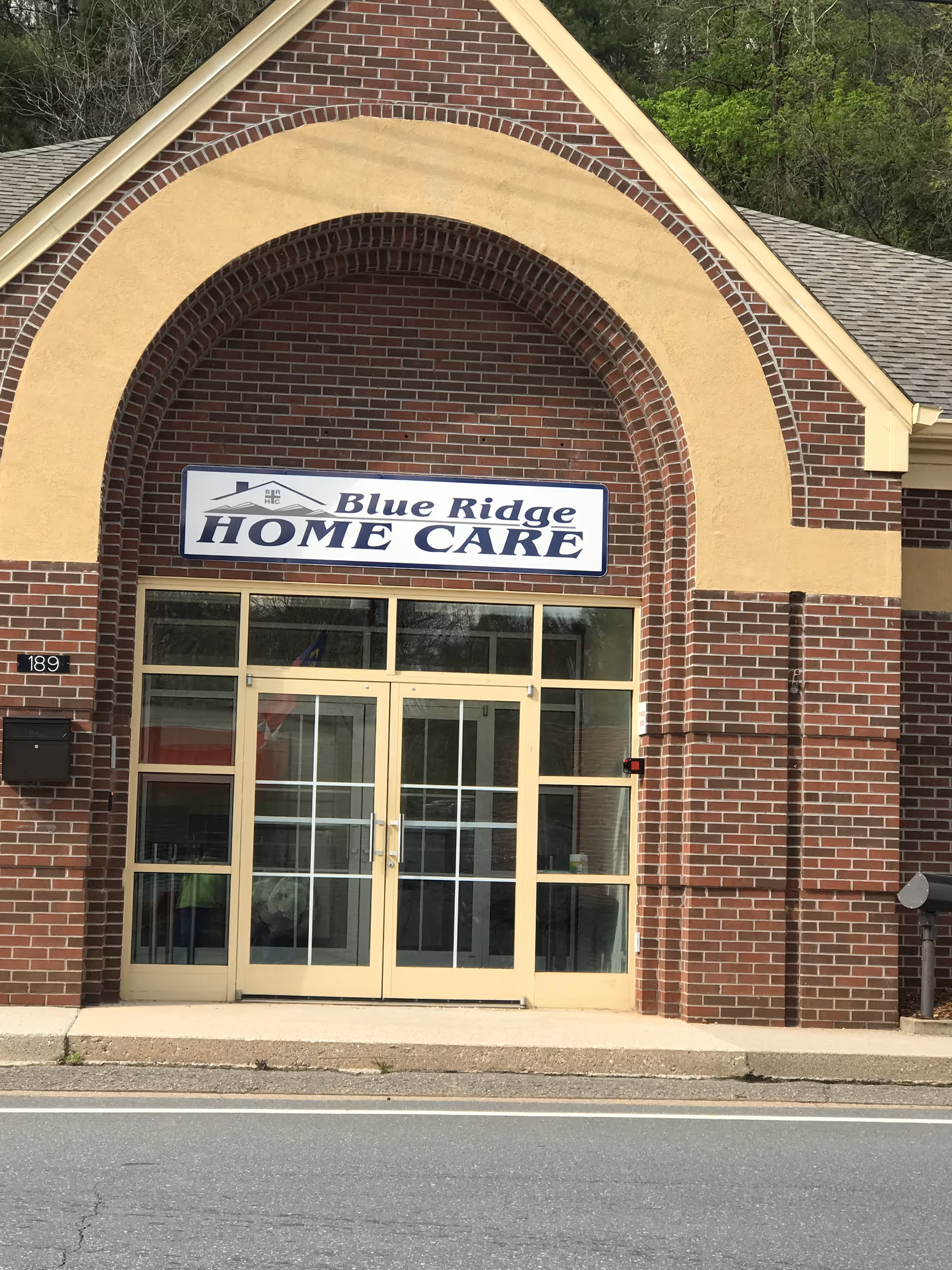 Brick building with arched entrance and blue sign reading Blue Ridge Home Care.