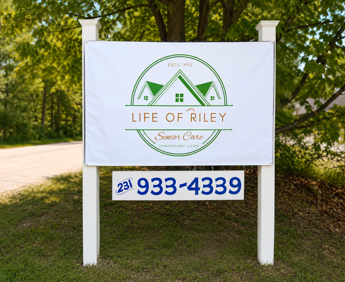 Outdoor sign on posts showing Life of Riley Senior Care logo and phone number.