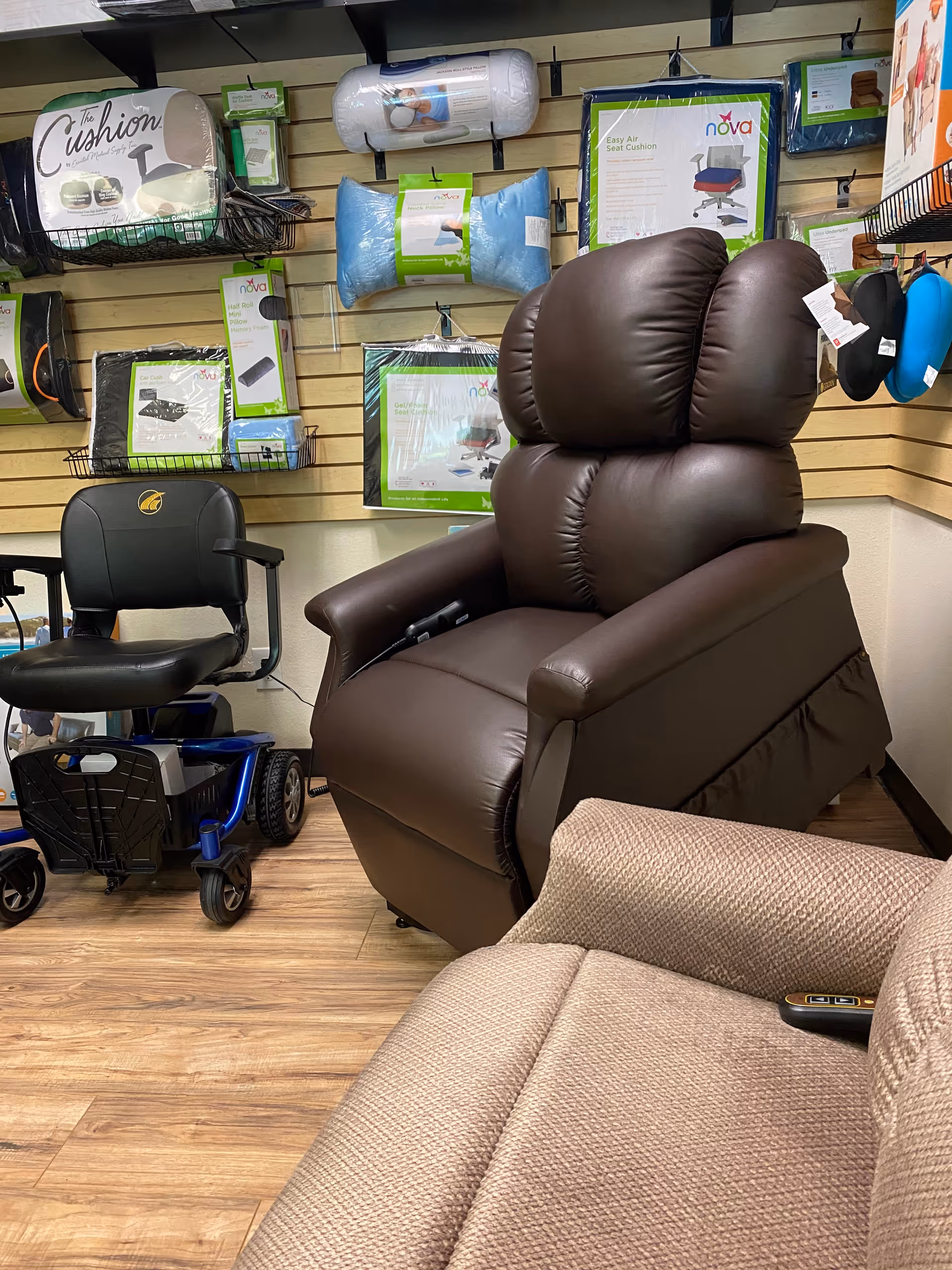 Indoor showroom with a brown reclining chair, beige sofa, and mobility aids on display.