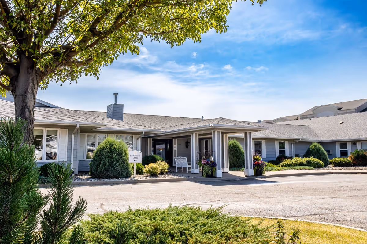 Exterior view of a single-story assisted living facility entrance with a covered portico.