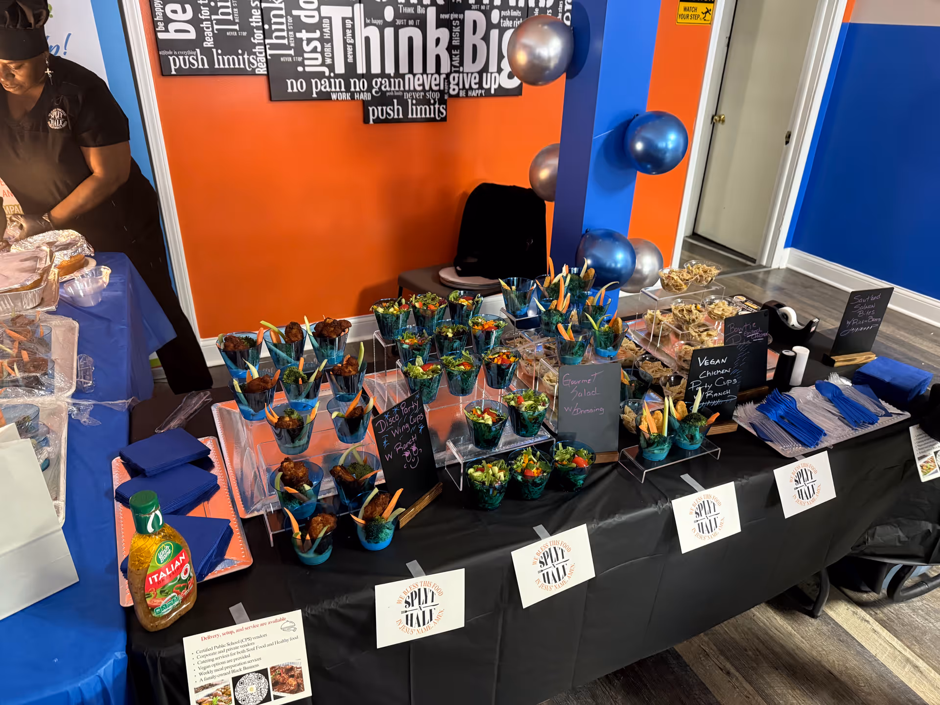 Colorful food display on a table in a bright indoor facility with exercise balls.