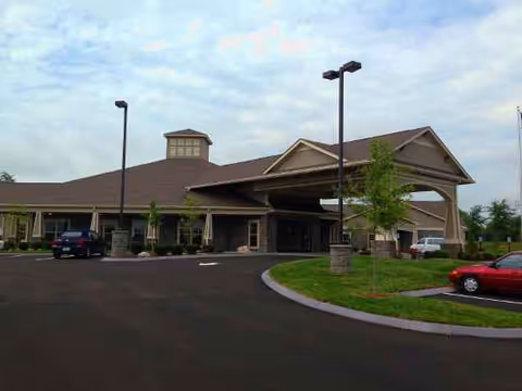 Exterior view of Morning Pointe Lexington-East showing the front entrance with a covered drive and parking.