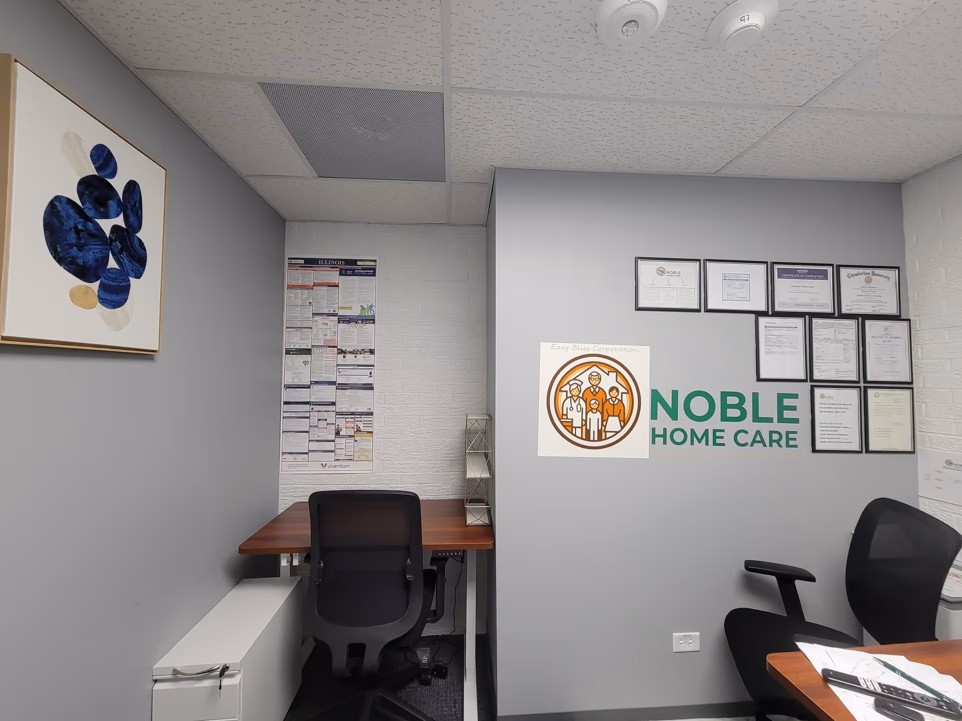 Noble Home Care office interior with wall logo, certificates, and a desk.