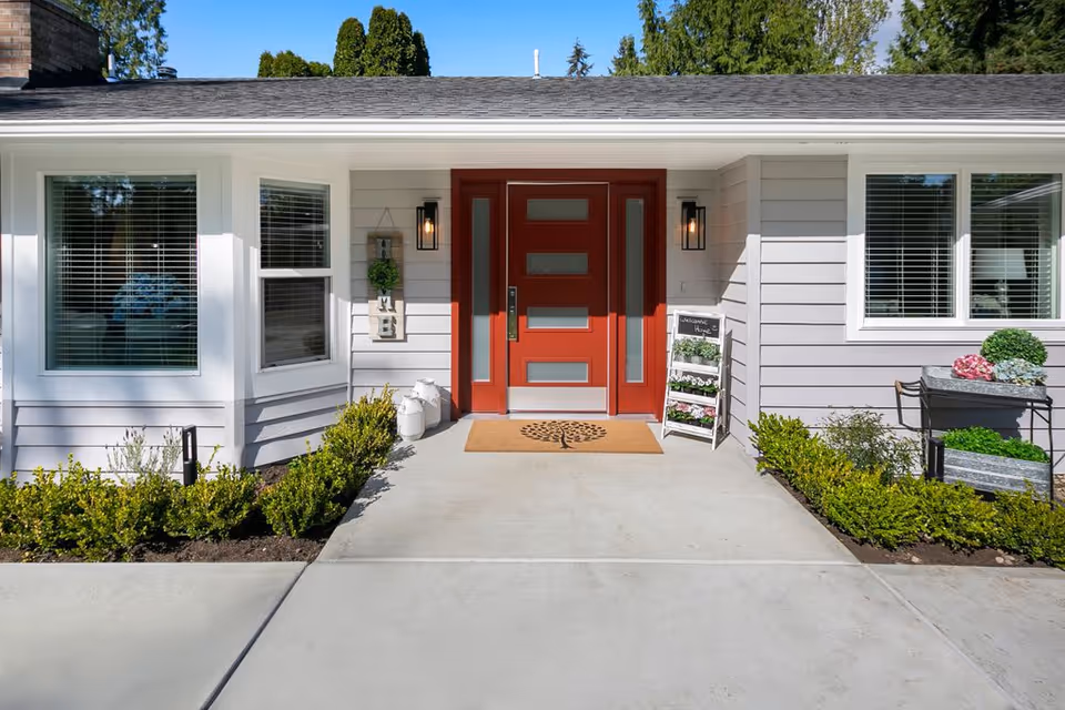 Entrance of Ashford at Firdale Village with red front door and welcoming decor.