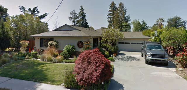 Single-story residence with front yard, driveway, and parked SUV in front of a ranch-style senior home.