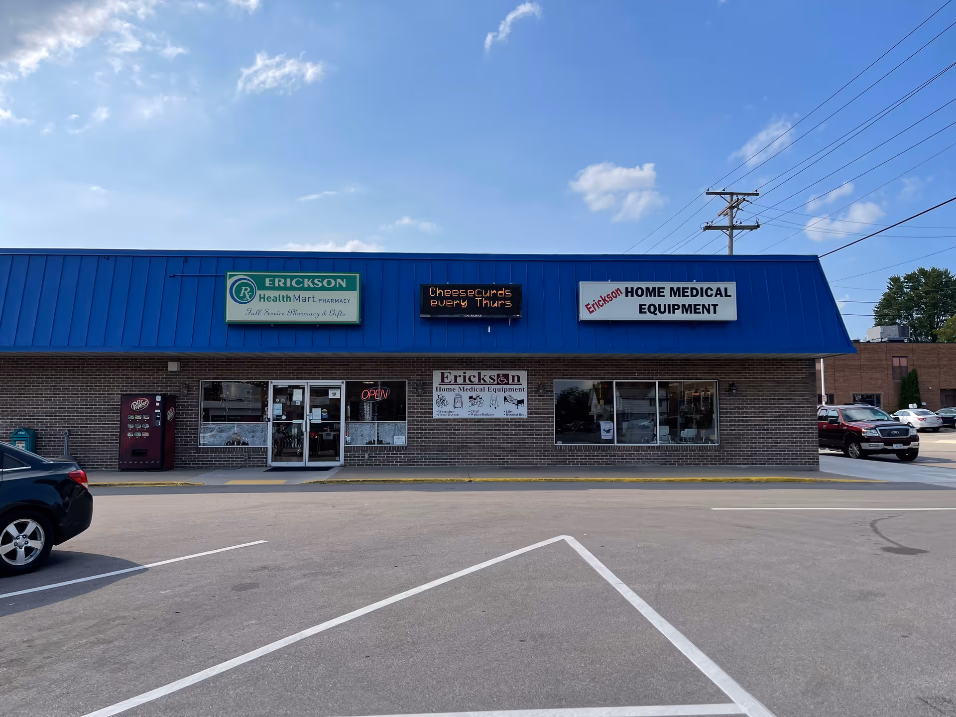 Exterior view of Erickson Home Medical Equipment storefront with a blue awning and parked cars.