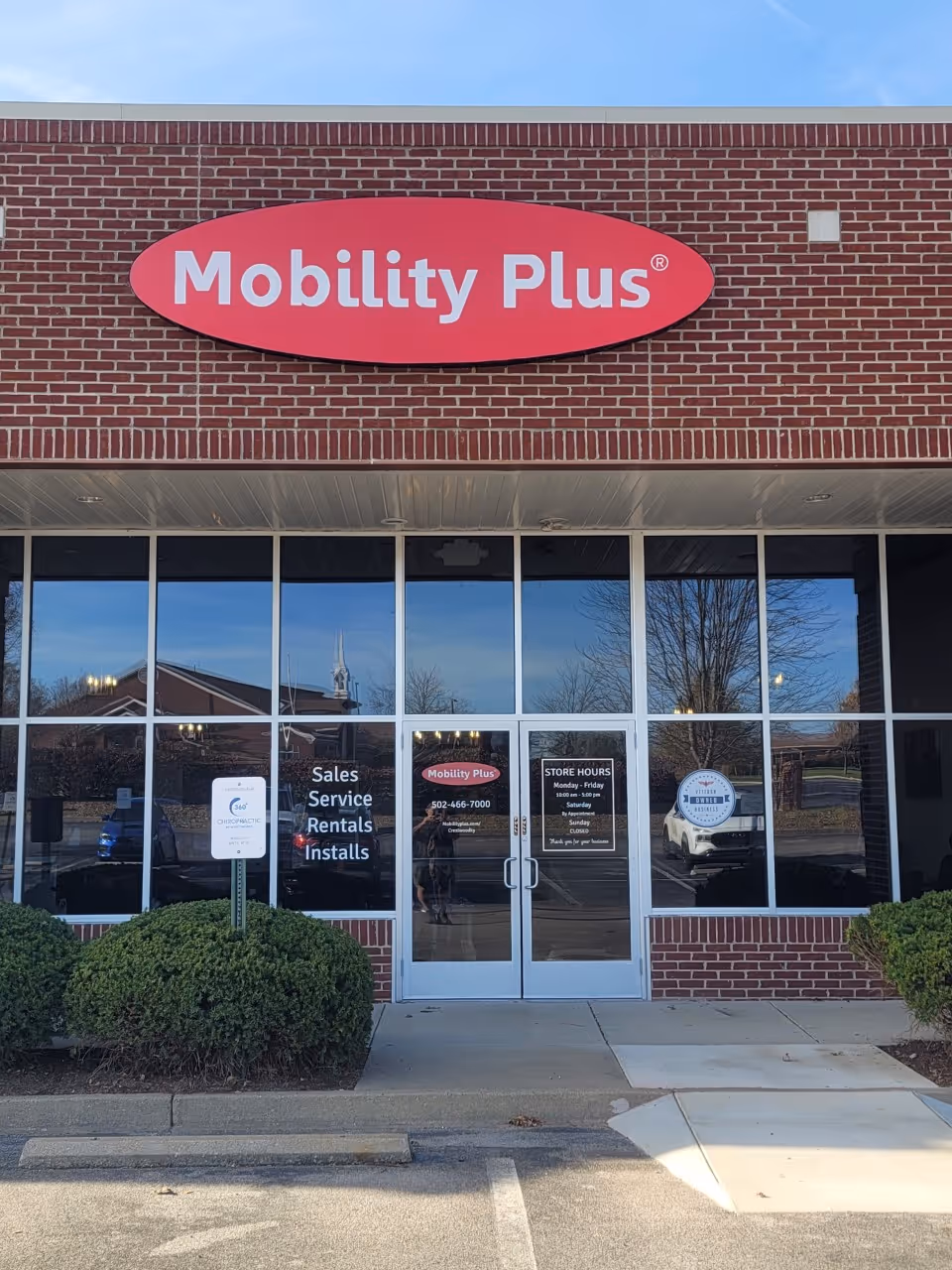 Brick storefront featuring a large red Mobility Plus sign on the front.