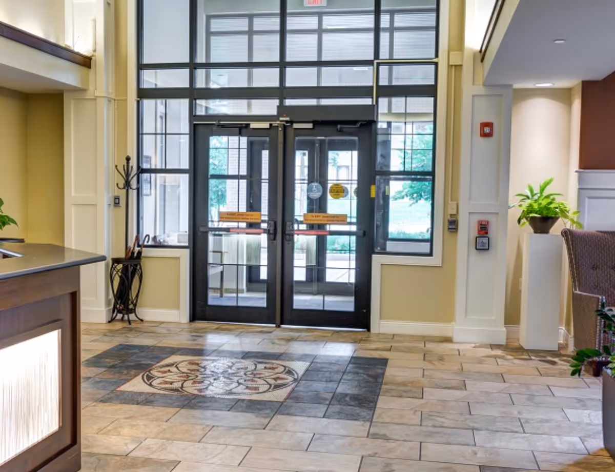 Lobby area of The Auberge at Highland Park with double glass doors and reception desk.