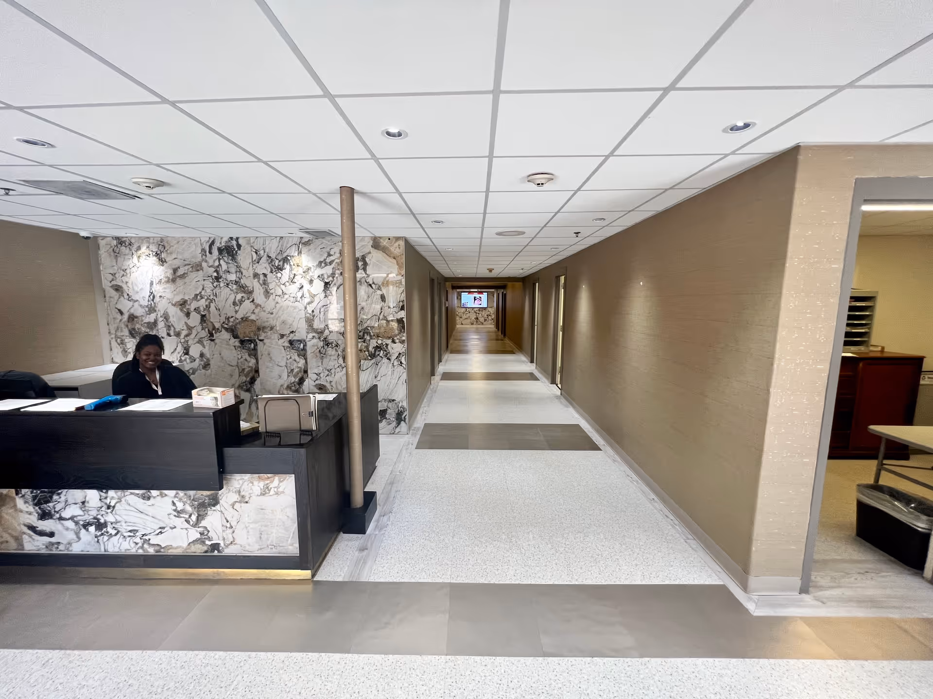 Hallway interior of River Towne Center with a reception desk and marble walls.