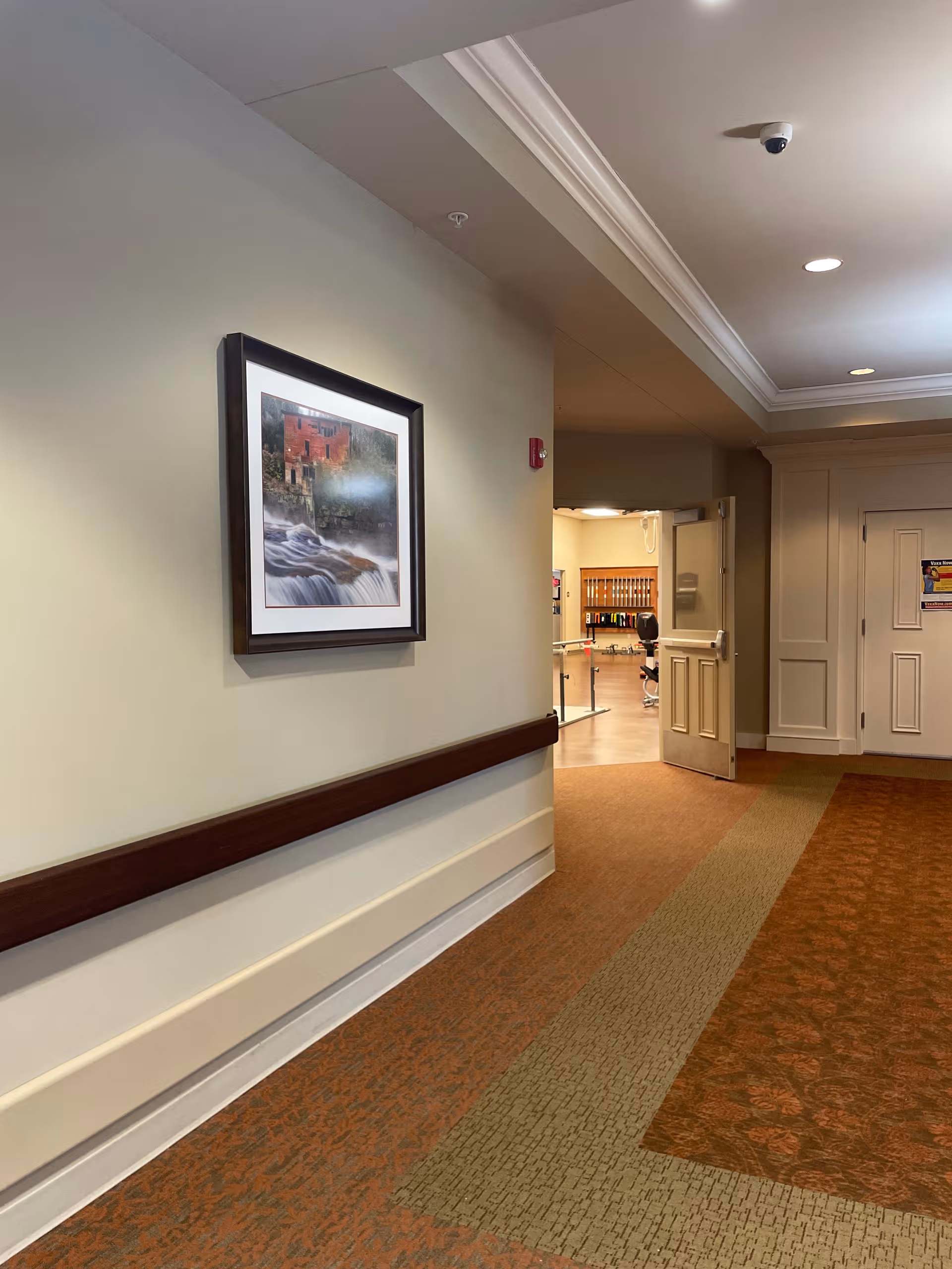 Hallway in Aspire West Alabama Recovery Center with framed wall art and open doorway