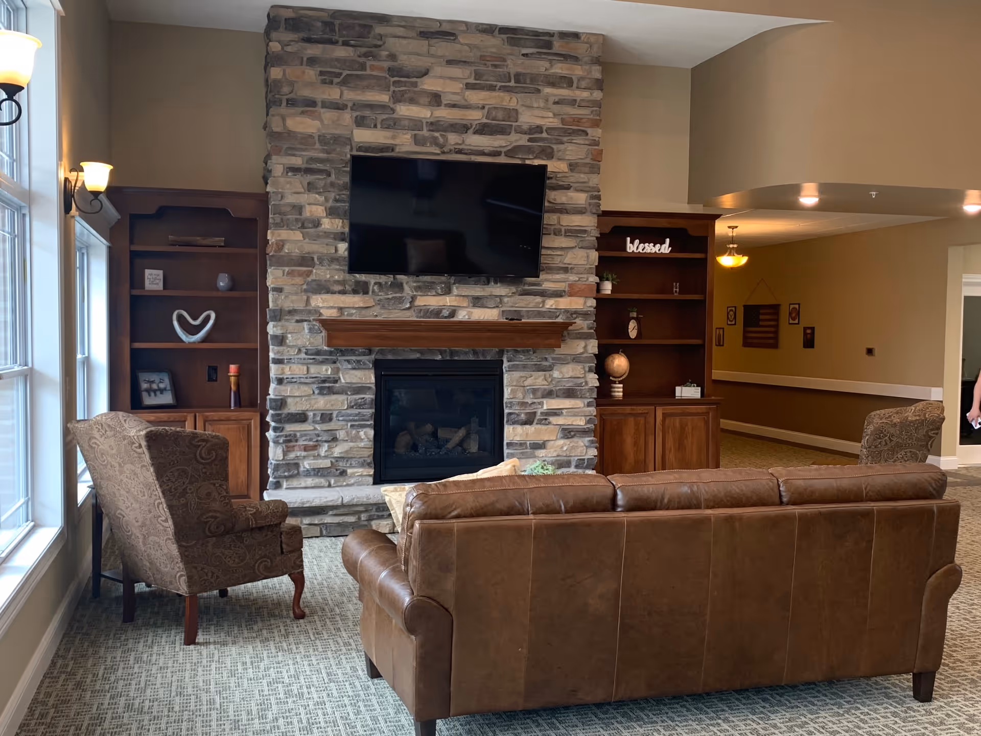 Stone fireplace with mounted TV and leather seating in a cozy lounge.