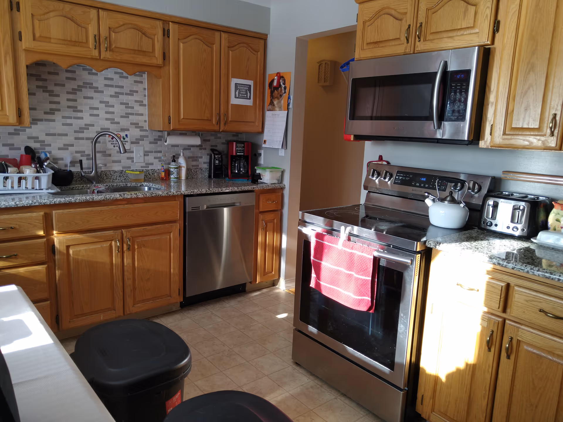 Wooden-cabinet kitchen with stainless appliances and granite countertops in an Ava facility.