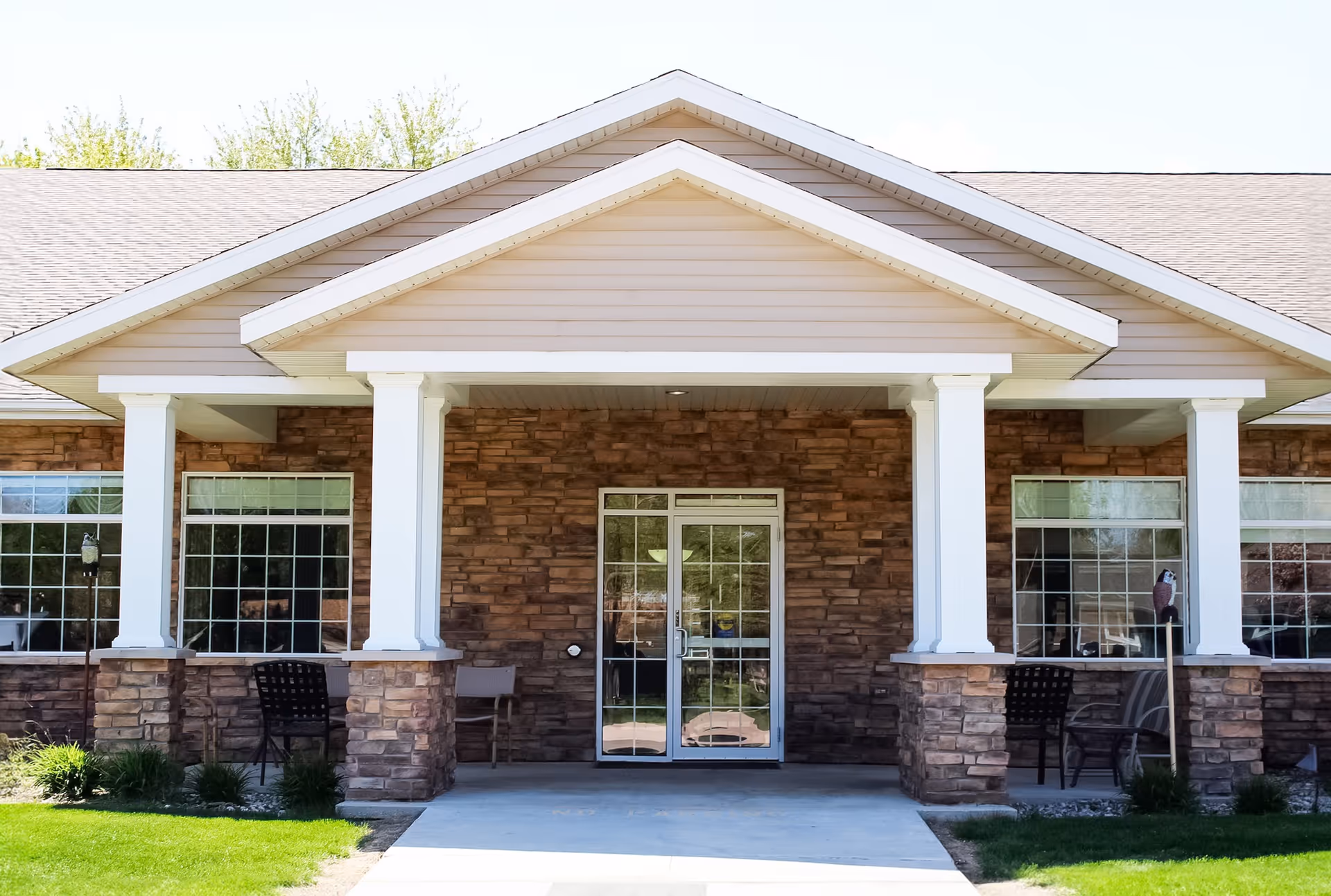 Front entrance of Accura Healthcare of Milford with stone columns and glass doors.