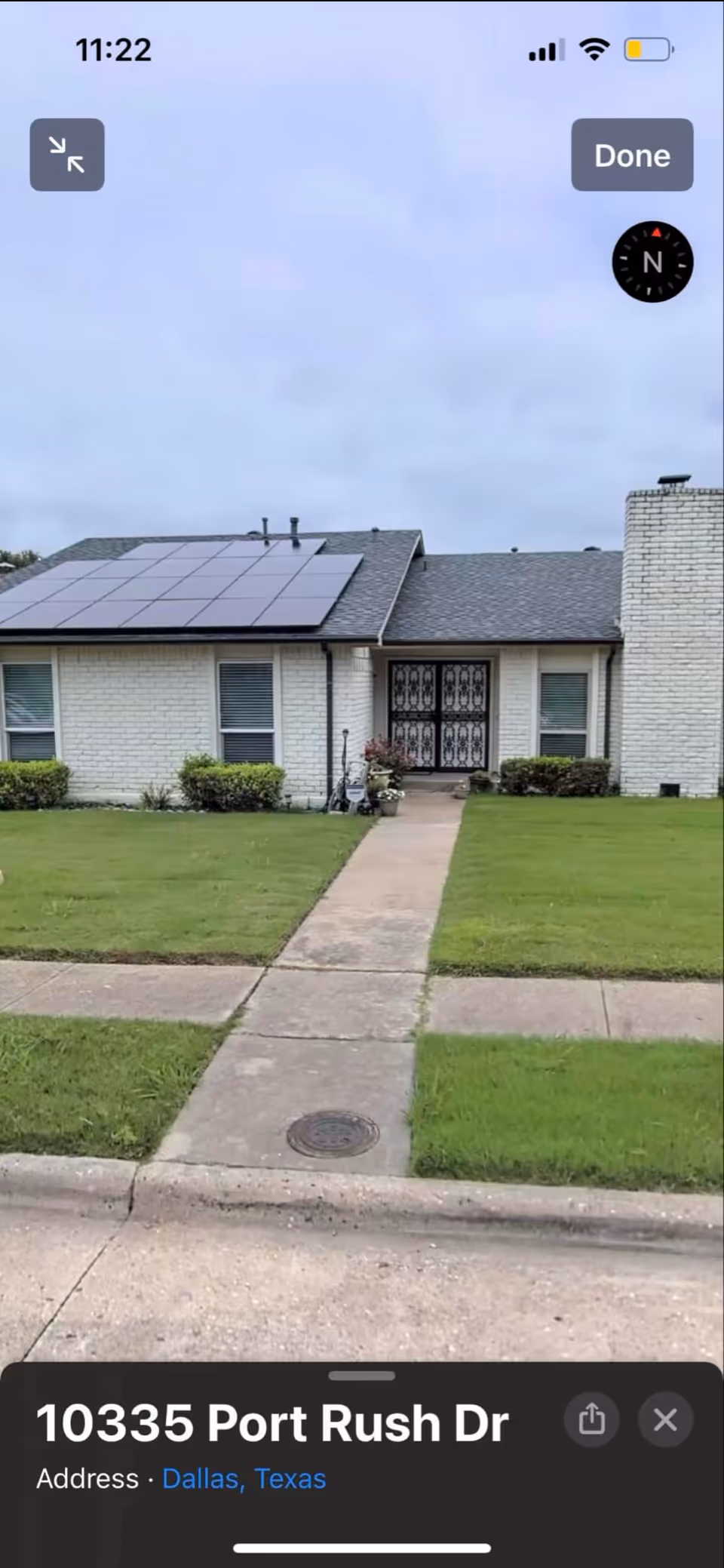 Front view of a single-story care home with solar panels and walkway.