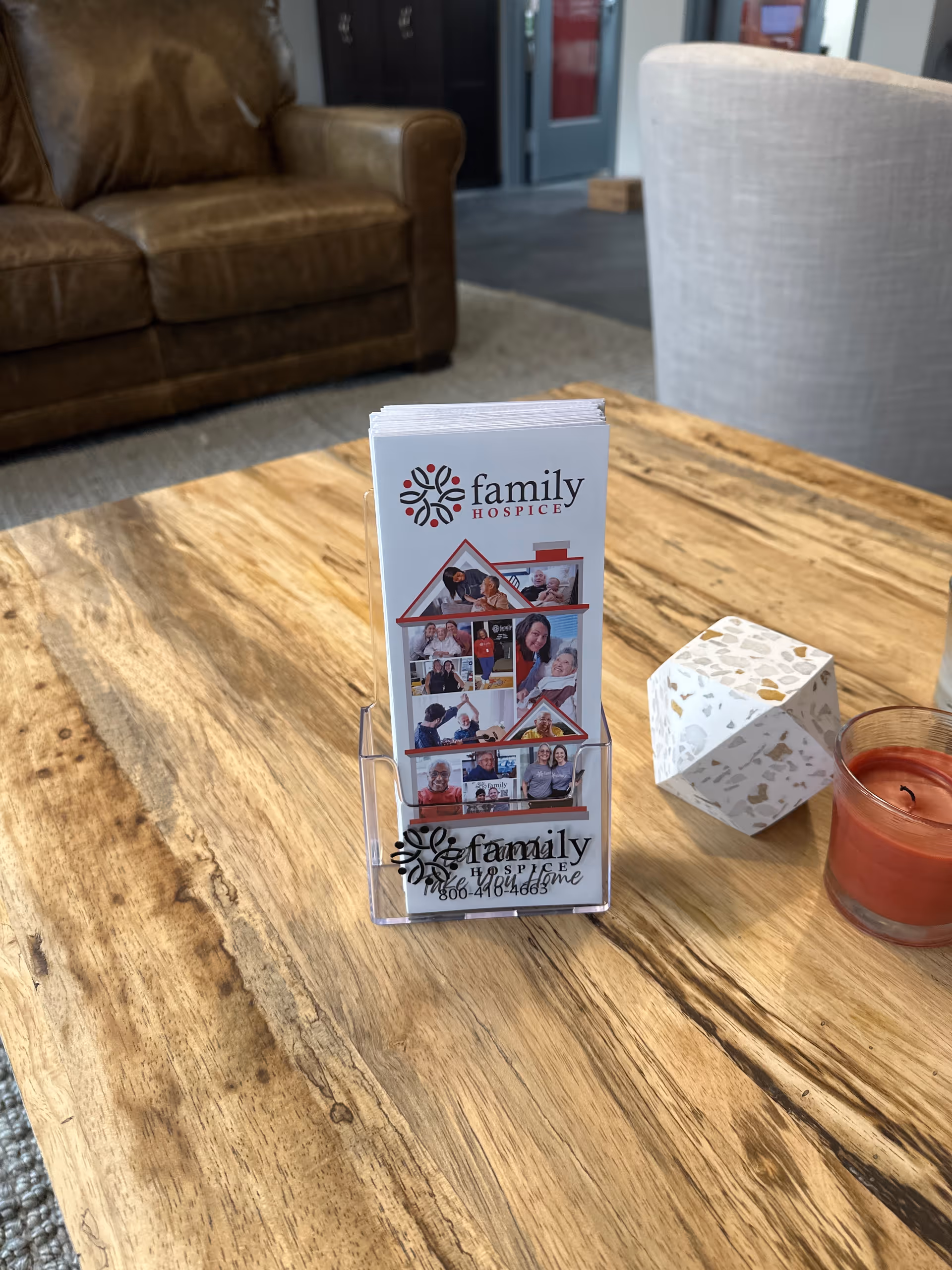 A brochure stand with Family Hospice brochure on a wooden table in a lounge.