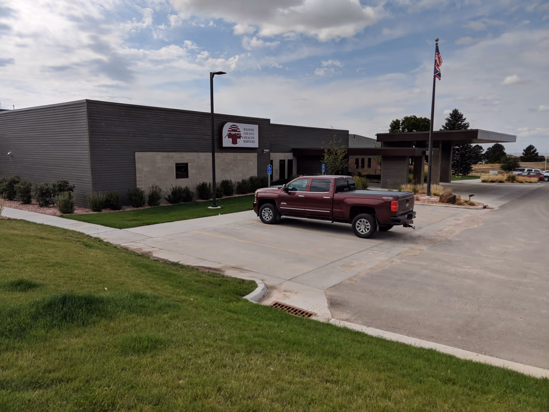 Exterior view of Weston County Health Services I with parking lot and pickup truck