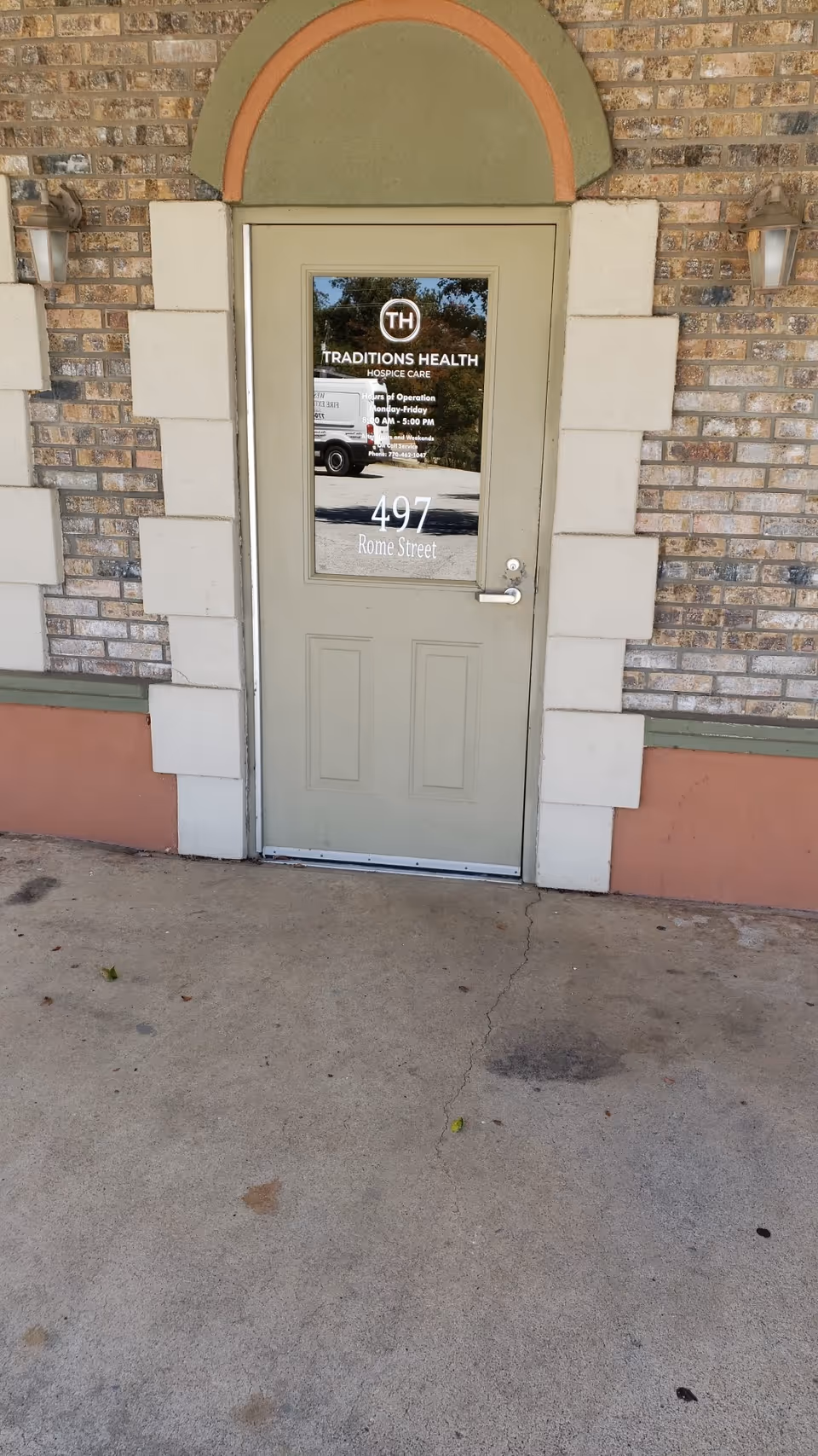 A brick exterior entrance door for Traditions Health Hospice Care at 497 Rome Street