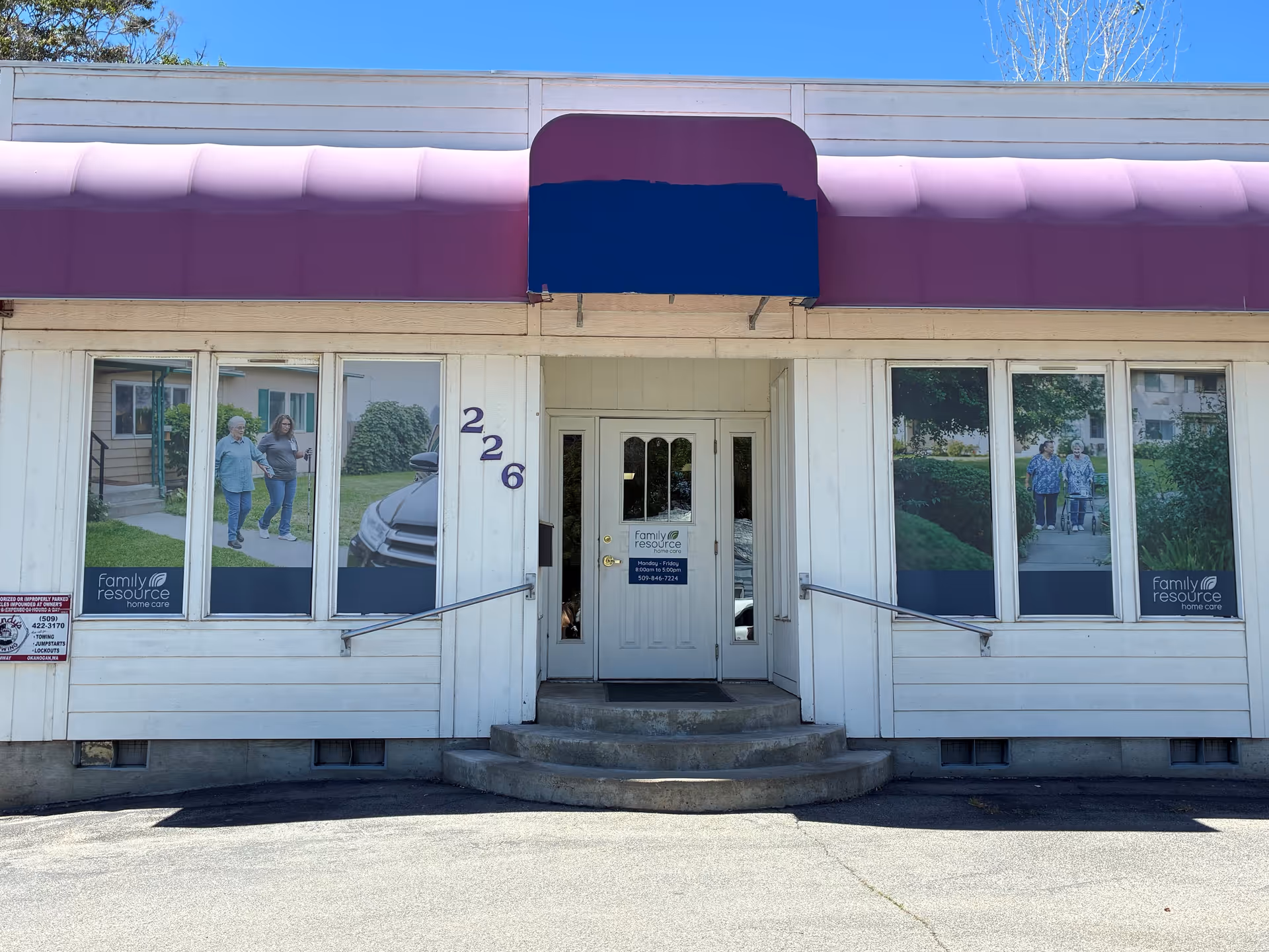 White storefront with purple awning and glass doors, posters of seniors in windows.