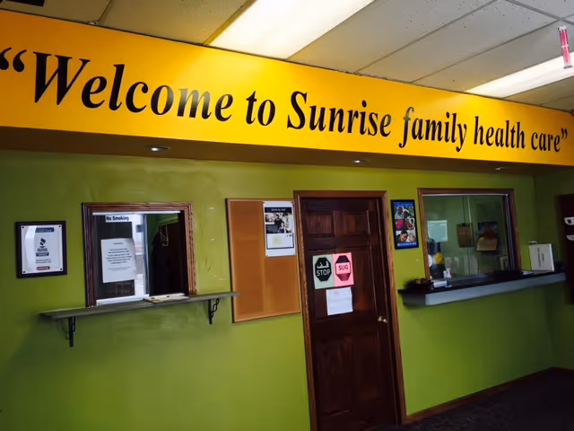 Bright lobby area with a yellow banner reading 'Welcome to Sunrise family health care'.