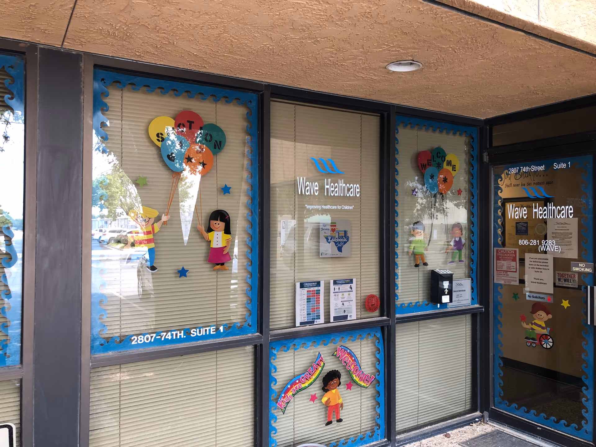 Front of Wave Healthcare Lubbock storefront with colorful window decals and cartoons.