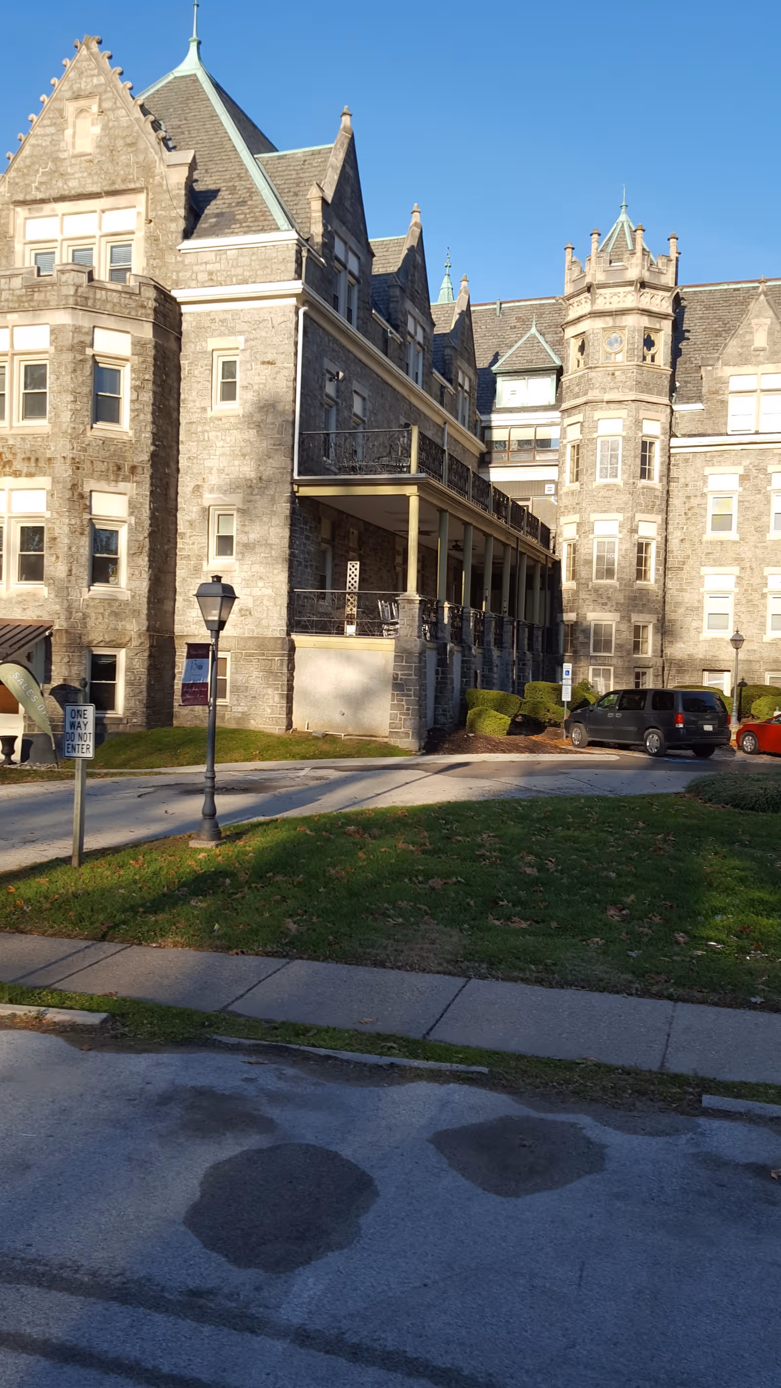 Simpson House exterior: stone turreted building with balconies and parked cars.