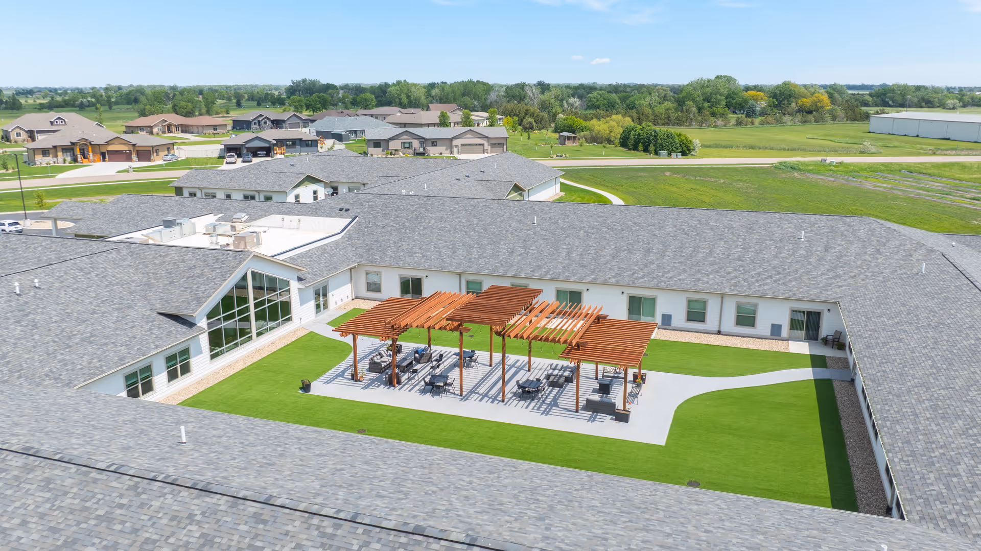 Aerial view of a senior living courtyard with a wooden pergola and seating.