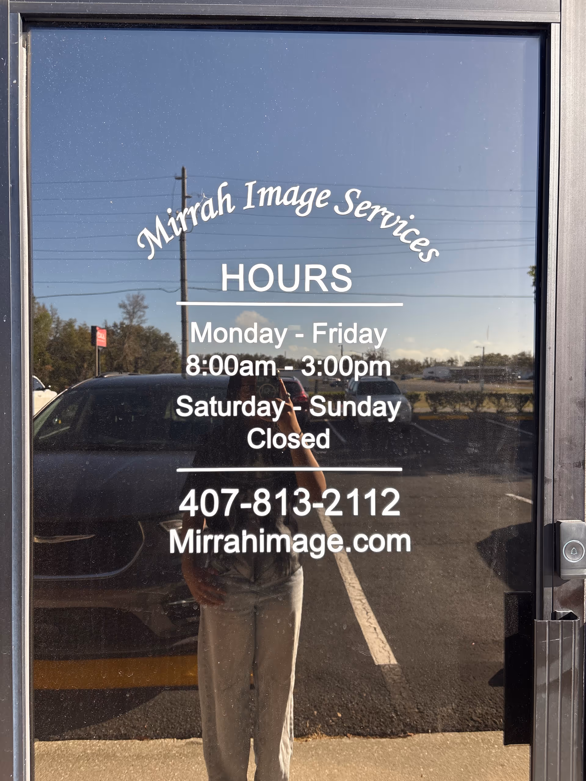Glass door featuring Mirrah Image Services hours, phone, and website.