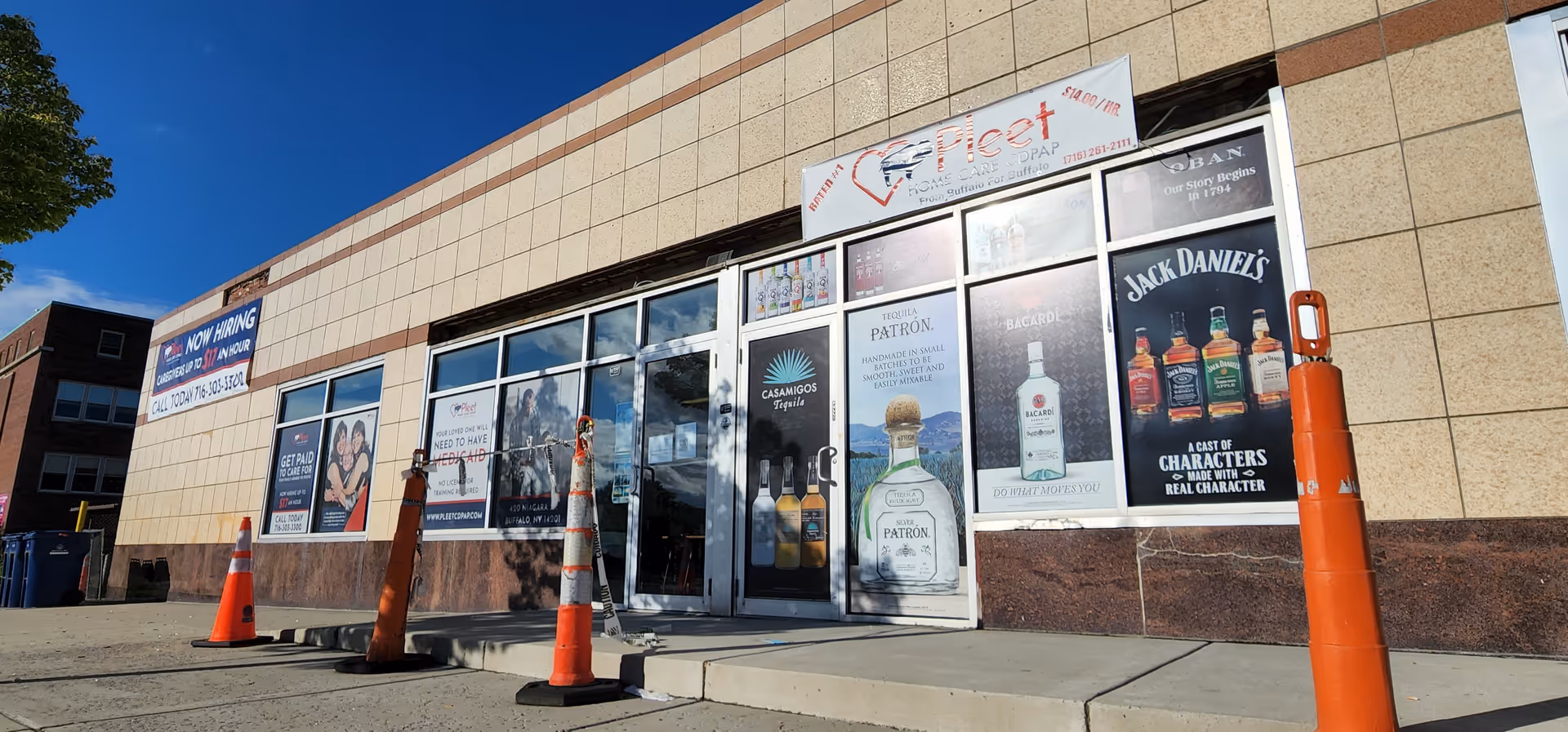 Exterior of Pleet Home Care CDPAP storefront with posters and orange cones.