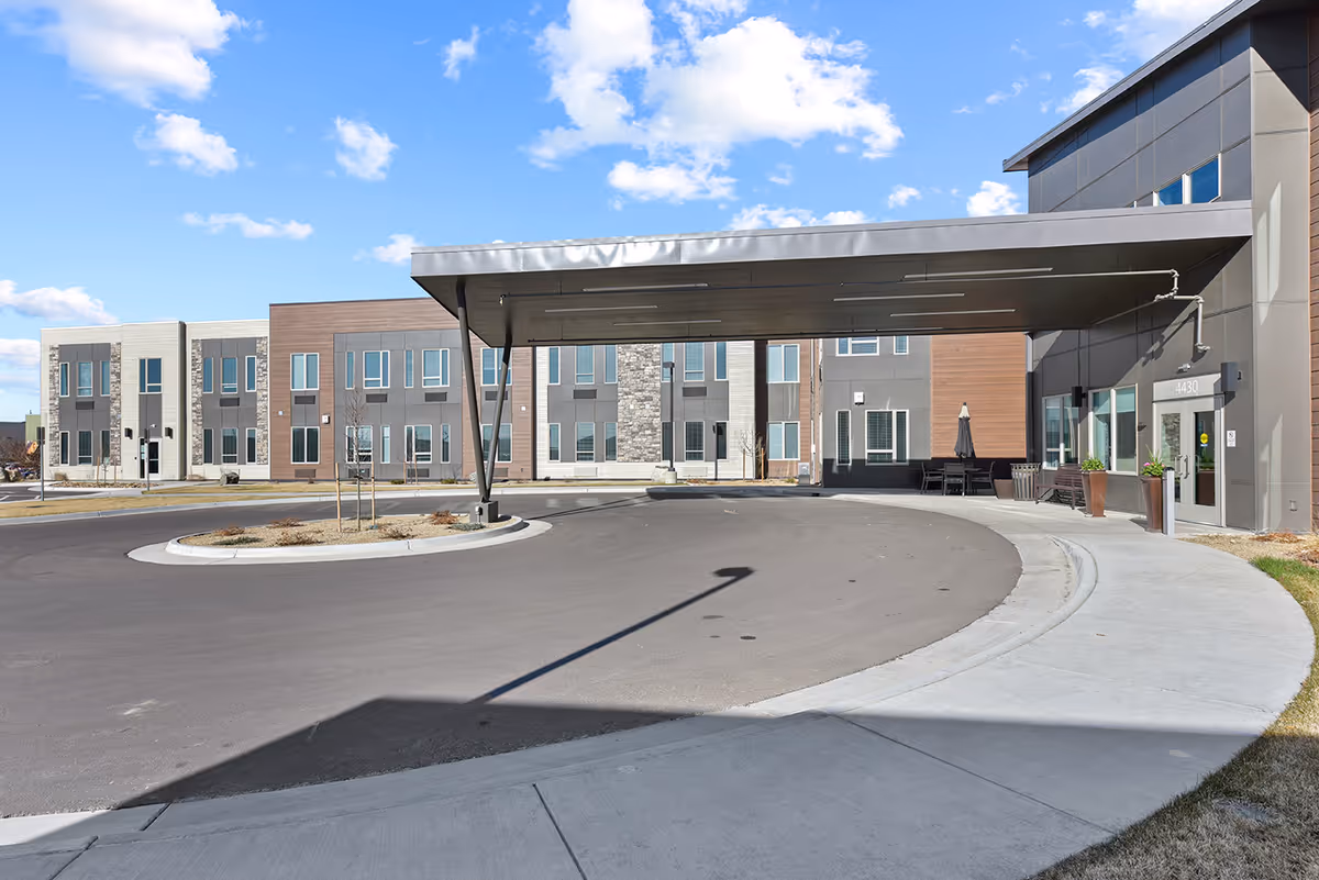 A circular driveway leading to the entrance of The Lodge at Greeley senior living facility.
