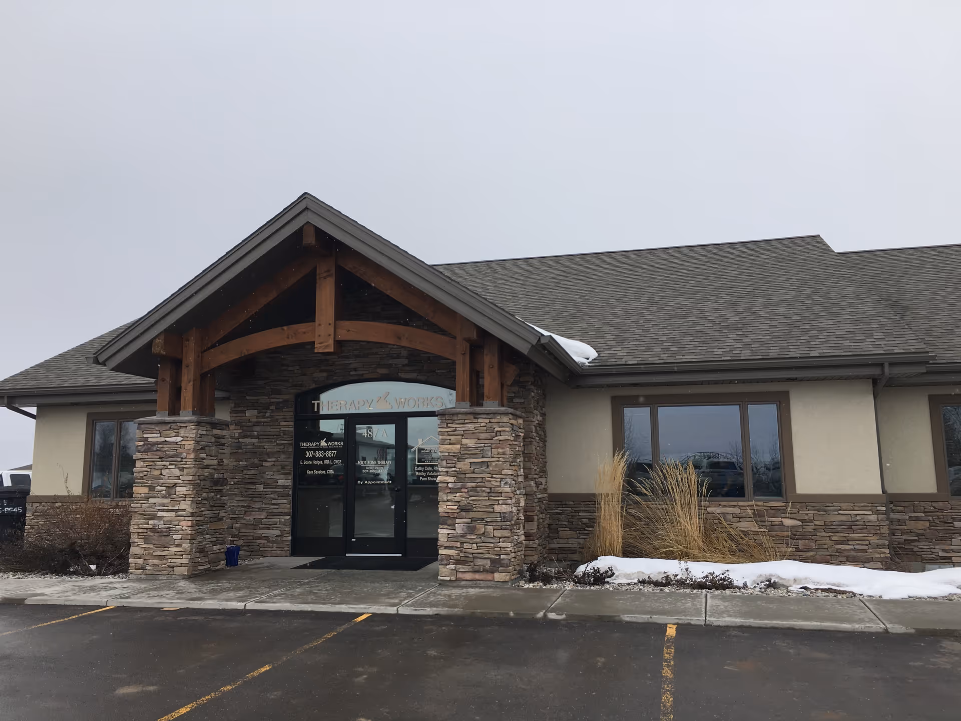 Front exterior of Premier Home Health building with stone pillars and wooden entrance.