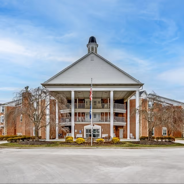 Front view of Colonial Heights Senior Living building with tall columns and flagpoles.