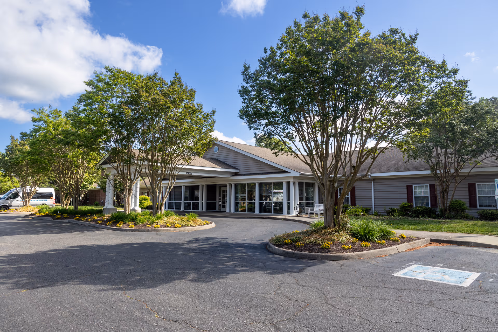 Front view of Commonwealth Senior Living at Kilmarnock entrance with driveway and trees.