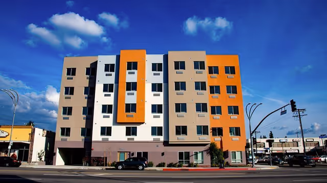 Colorful multi-story senior living facility sits along a busy street.