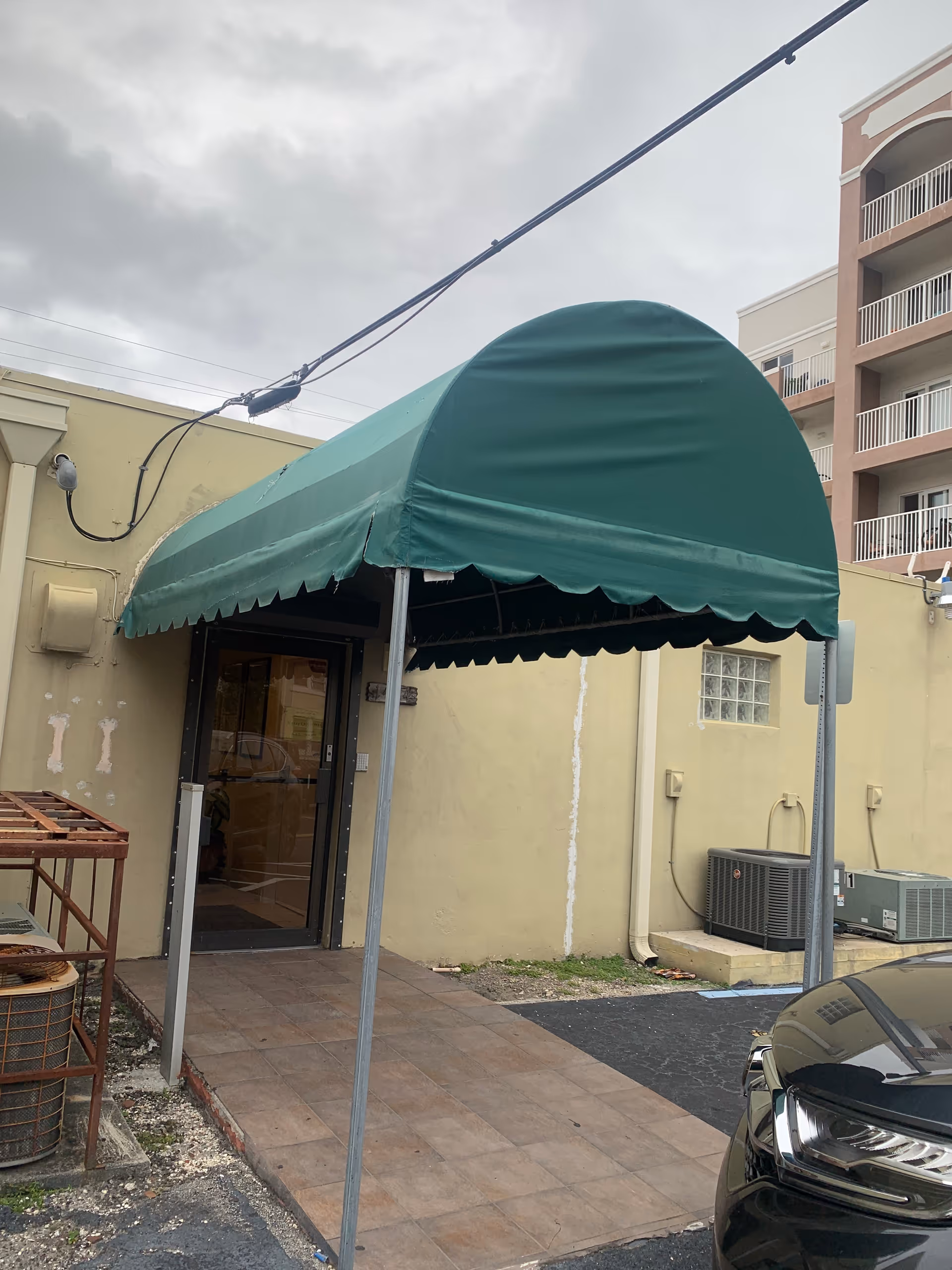 Green curved canopy covers a doorway at the Fatima Home Care exterior entrance.