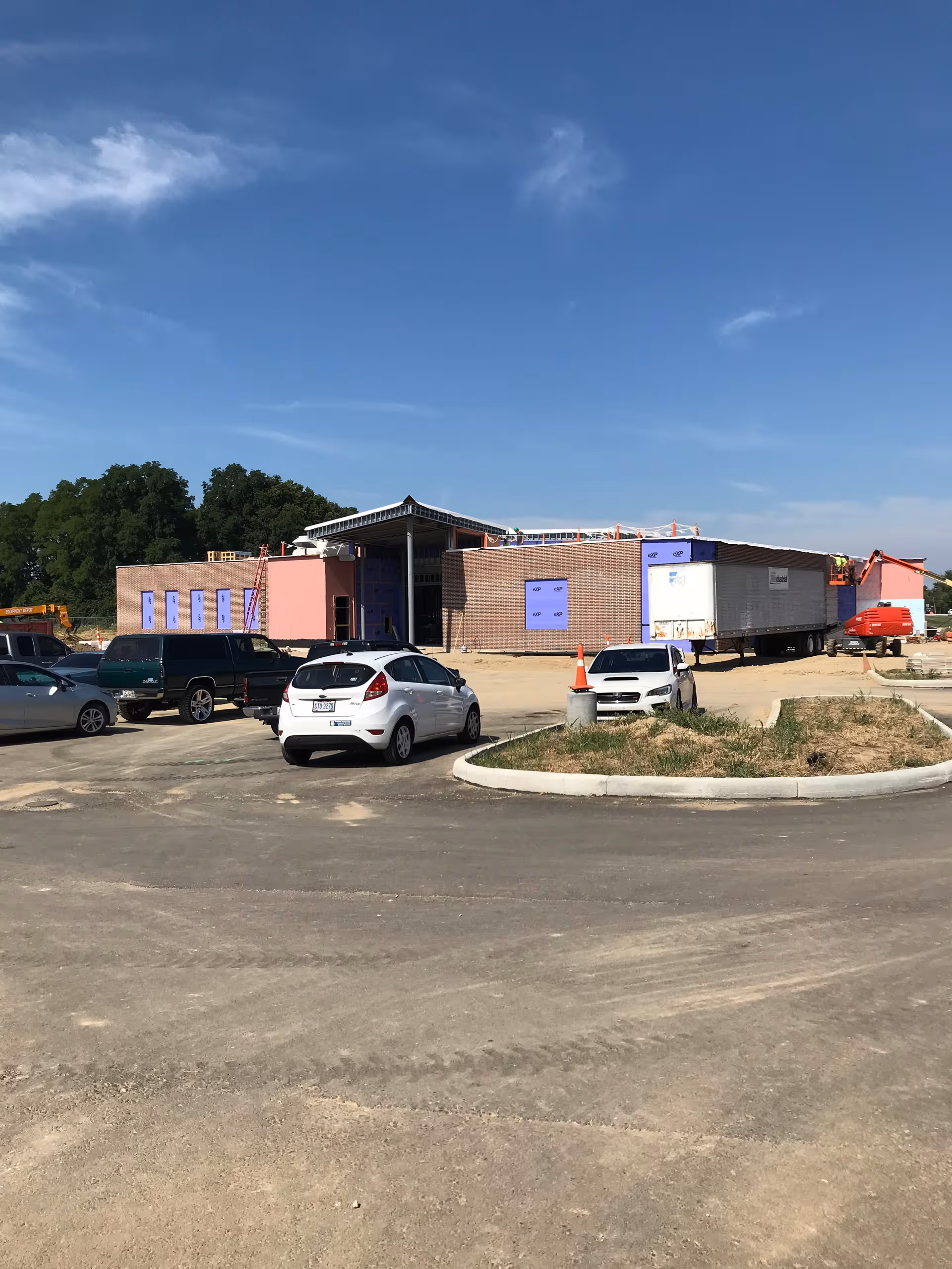 Front of Cypress Pointe Health Campus under construction with brick walls and parked vehicles.