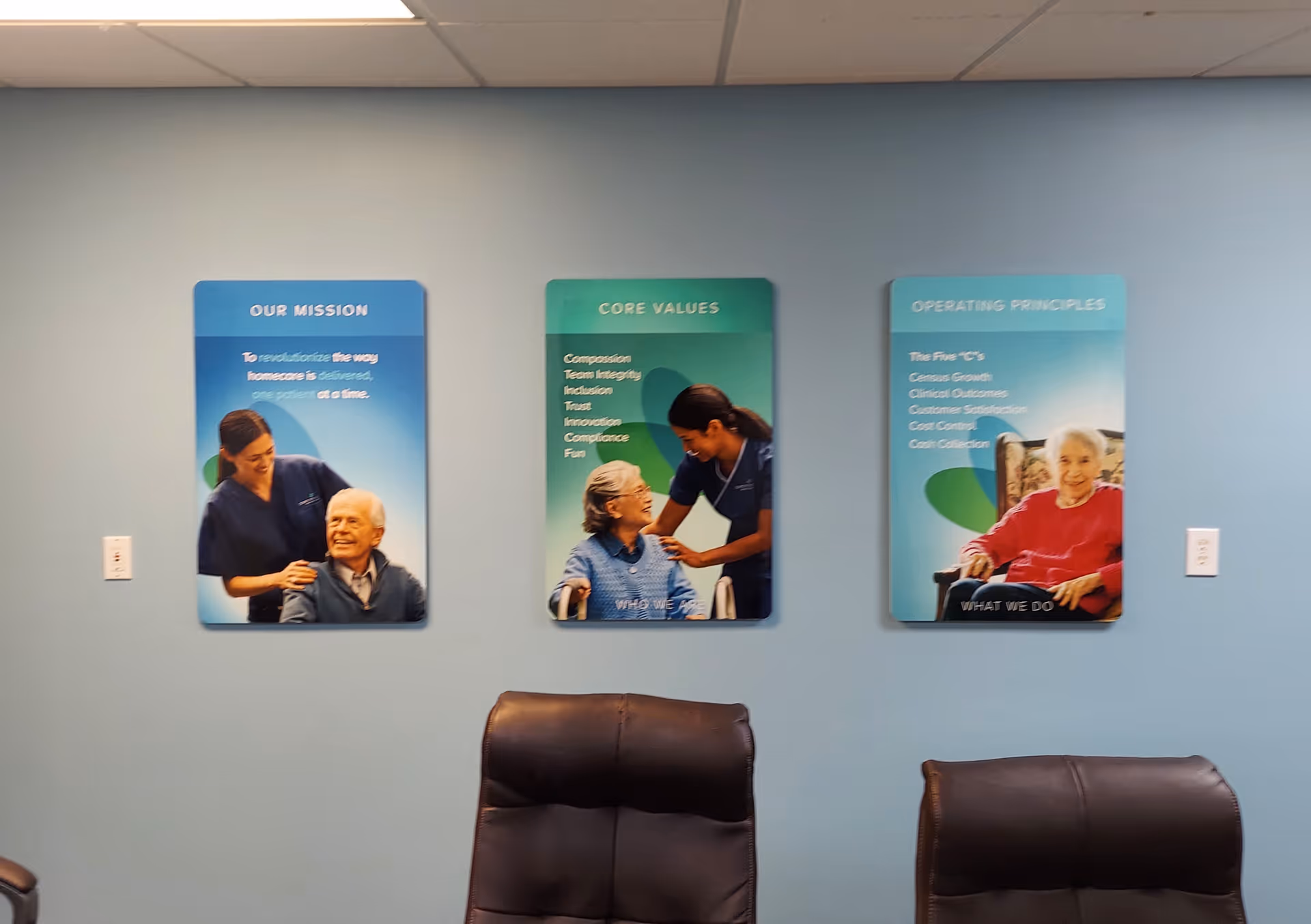 Interior wall with three posters and chairs in a reception area.