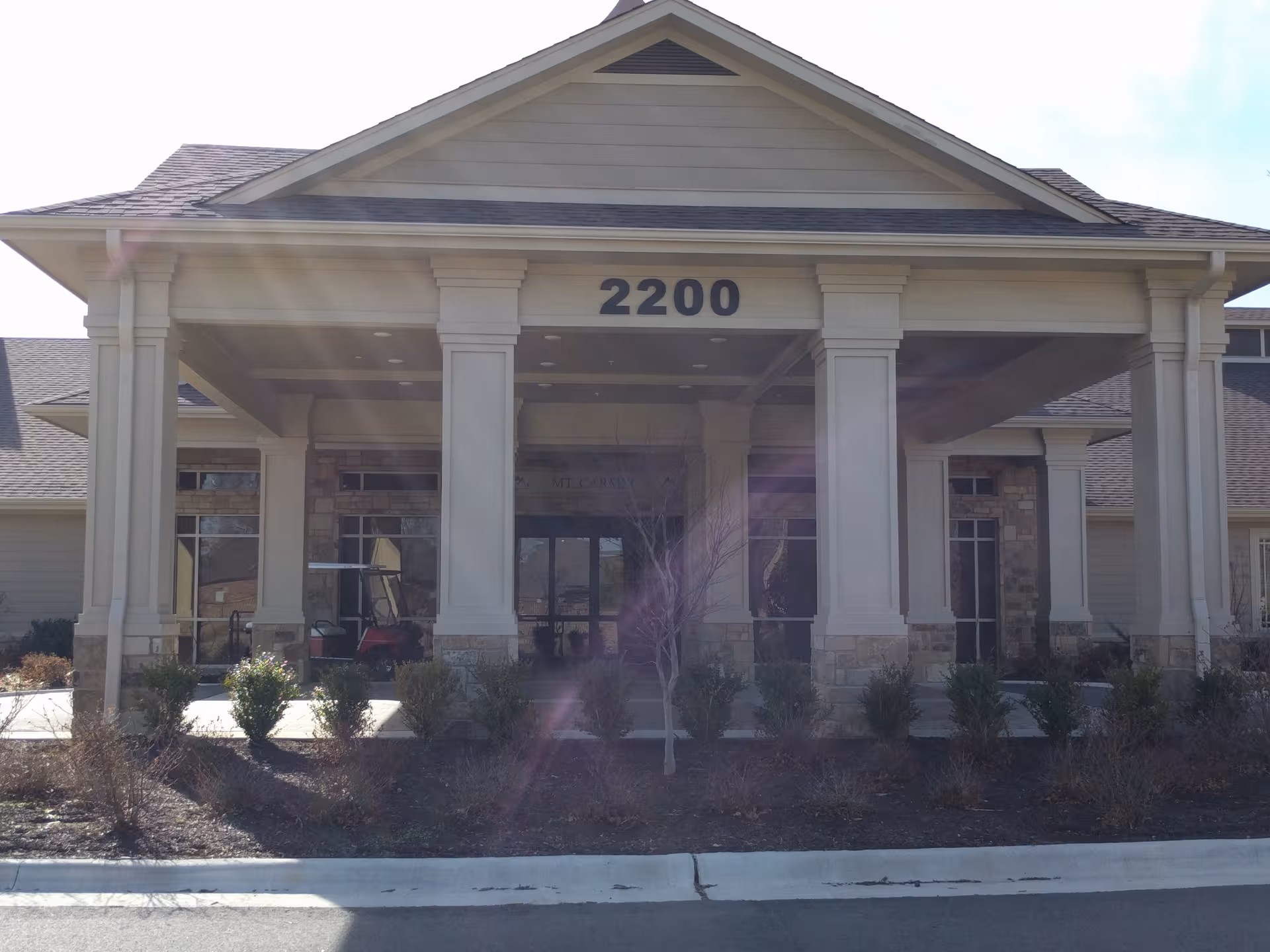 Front view of Village on the Park Rogers facility with columns and entrance.
