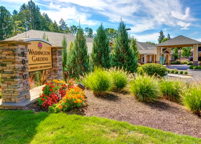 Front exterior view of Washington Gardens Memory Care with landscaped entrance and stone sign