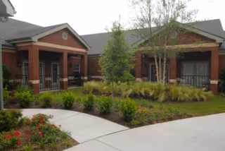 Exterior view of Truewood by Merrill River Park senior living building with landscaped entrance.