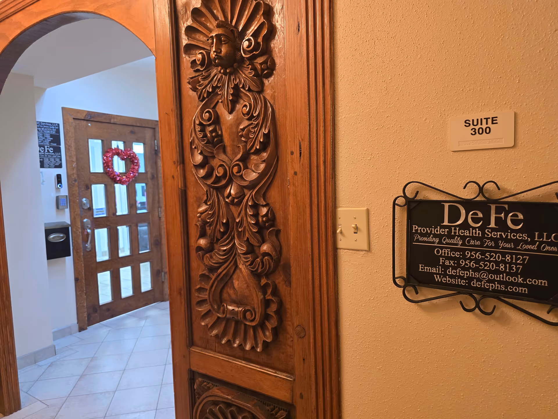 This image shows a carved wooden door panel in a hallway beside Suite 300.